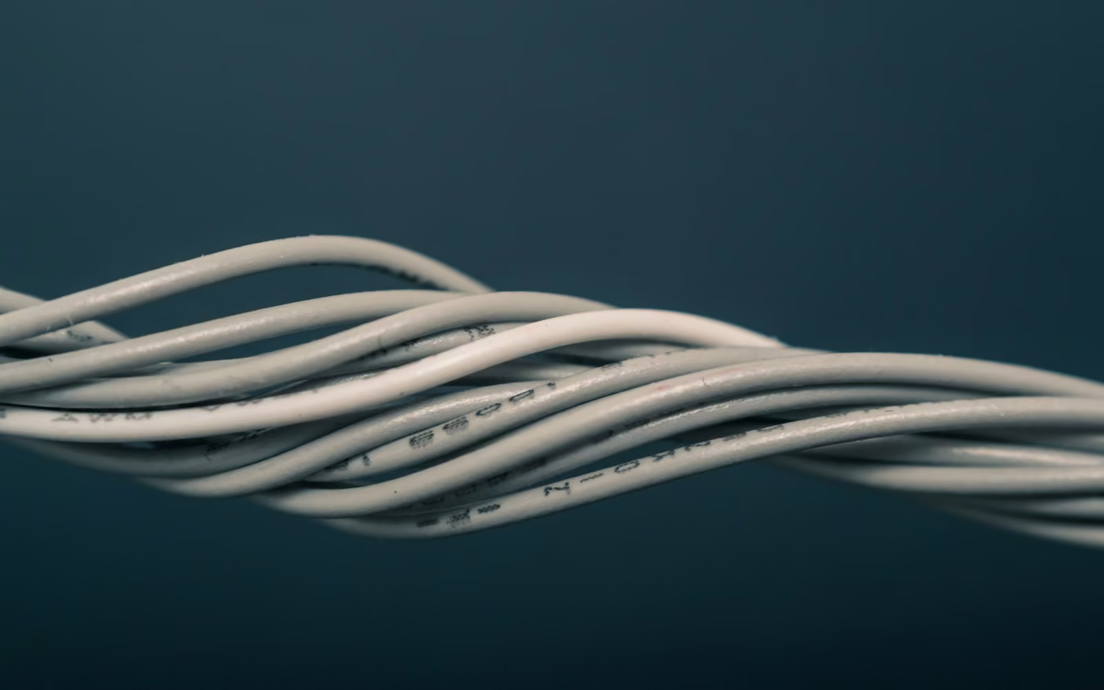 Kabel jaringan putih terpilin di atas latar biru gelap