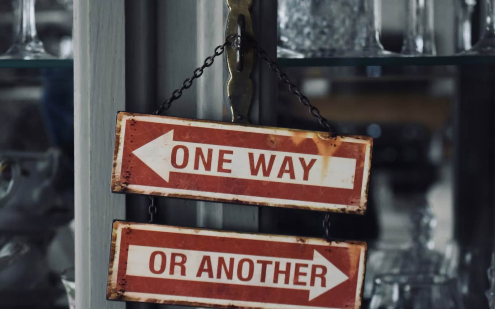 Dua papan penunjuk bertuliskan One way or another dengan panah berlawanan